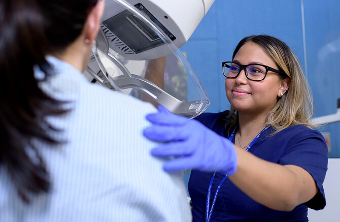 An MSK medical practitioner assists a patient during a breast cancer screening procedure.