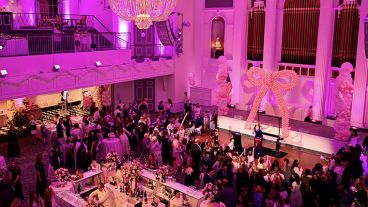 A roomful of young children and their parents partake in a festive Bunny Hop.