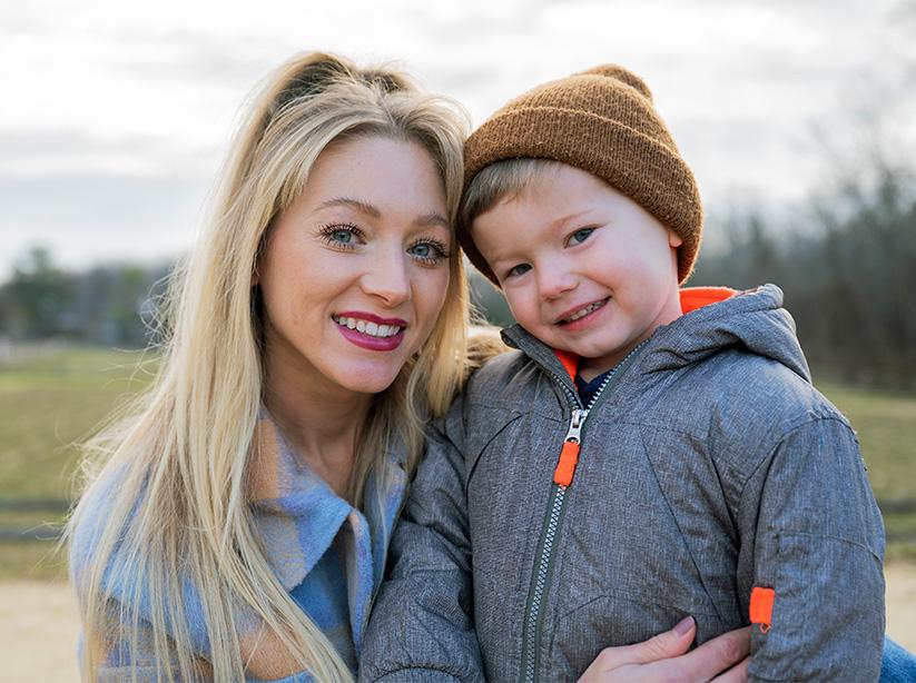 Patient Kelly Spill and her young son embrace as they look at the camera. 