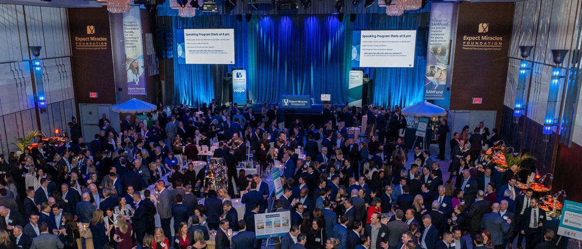 A large crowd gathers at a cancer fundraising event in a ballroom.  