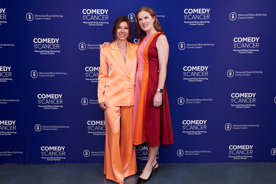 Jennifer Rogers and Niccole Kroll posing in front of the MSK backdrop at Comedy vs Cancer 2024.