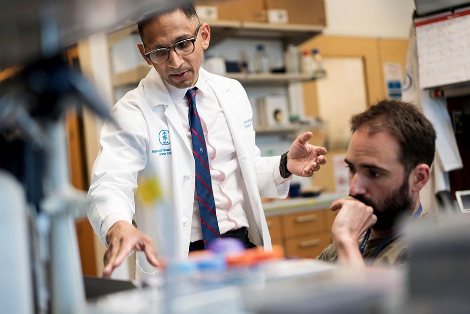 Vinod Balachandran, MD, in the lab with a researcher 