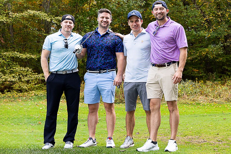 A group of men are gathered on a golf course at a cancer fundraising event. 