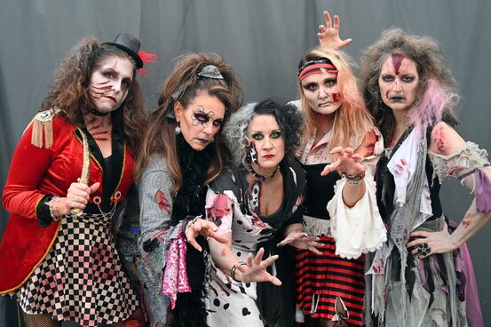 Group of zombie moms in full zombie costumes and makeup. 